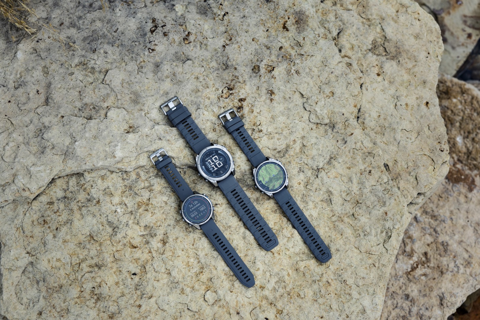 Gamme Garmin Fenix 9 : les trois tailles 43, 47 et 51 mm à lunette titane posées sur la roche