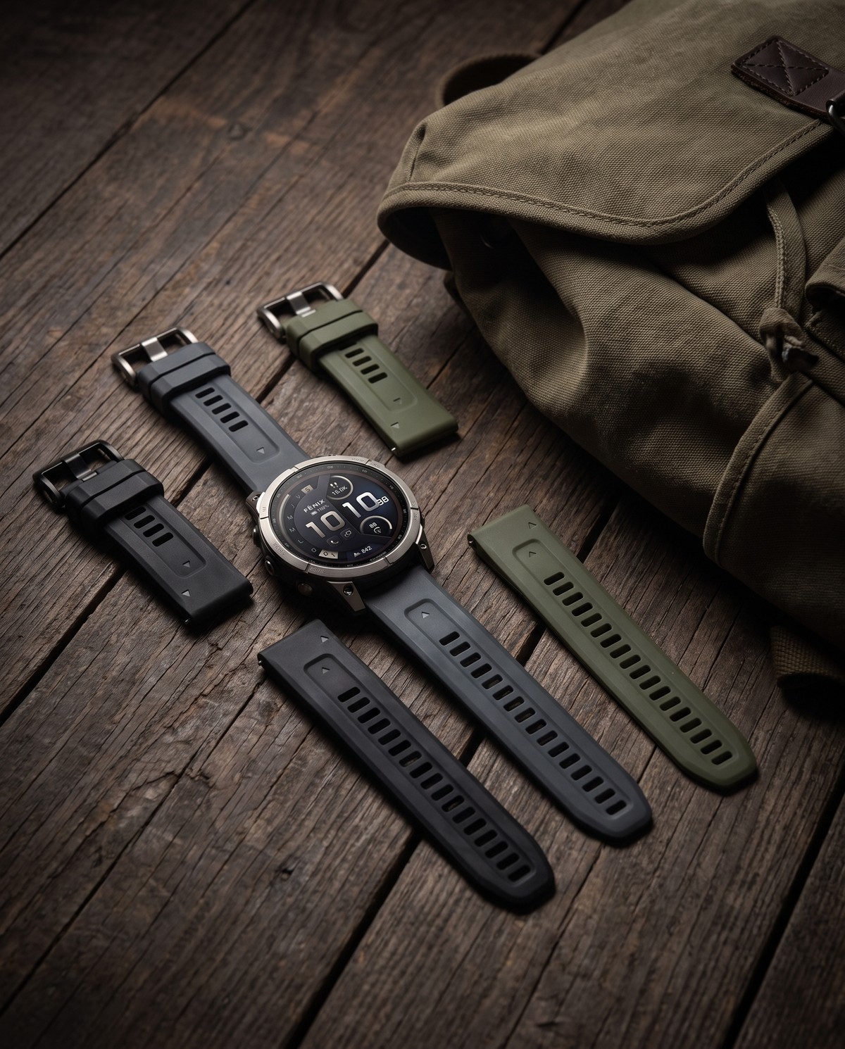 Garmin fēnix 9 Pro inReach 51 mm posée près d'un sac de trek et de bracelets QuickFit (vue d'illustration)