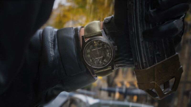 Le capitaine Price, fusil en main, la Hamilton Khaki Field Mechanical Call of Duty au poignet gauche, triangle jaune à midi, image du jeu Modern Warfare 4 publiée par Hamilton