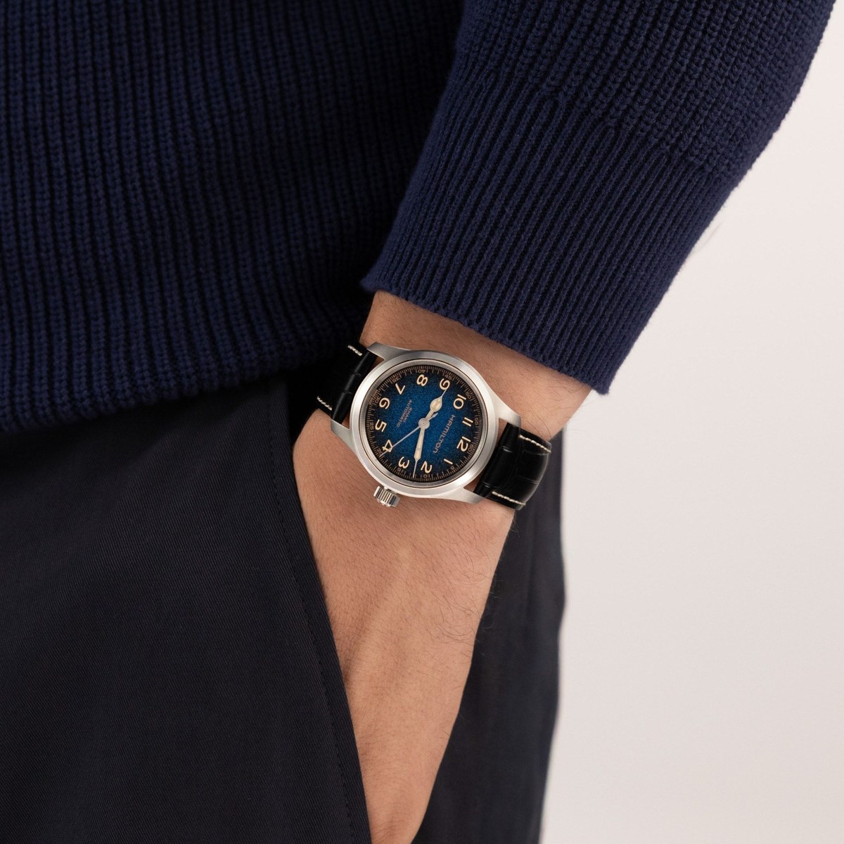 Hamilton Khaki Field Murph 38 mm cadran bleu dégradé portée au poignet sur bracelet cuir noir surpiqué blanc