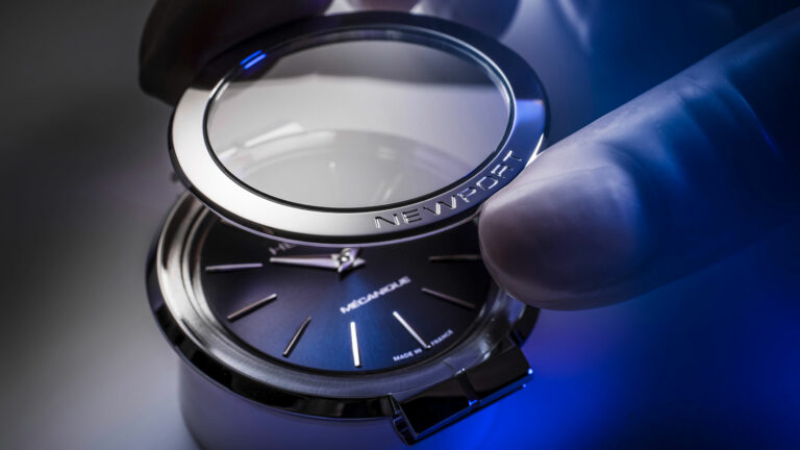 Assemblage d'une montre Herbelin Newport en atelier, pose de la lunette sur le cadran bleu