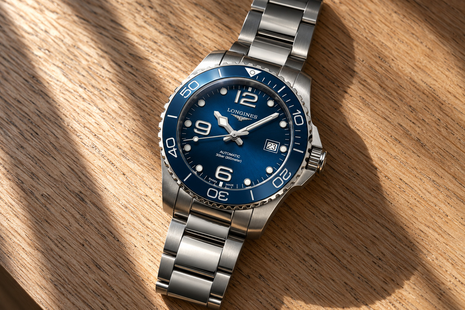 Longines HydroConquest GMT 41 mm cadran bleu soleillé, lunette céramique bleue et bracelet acier, sur un fond de lumières de port la nuit, vue d'illustration