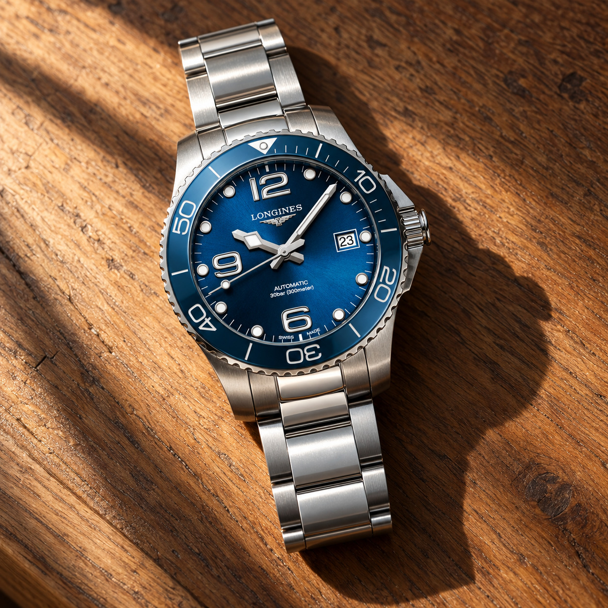 Longines HydroConquest 39 mm de la génération précédente, cadran bleu soleillé à chiffres arabes, lunette céramique bleue et bracelet acier, sur un fond de lac à l'heure bleue, vue d'illustration