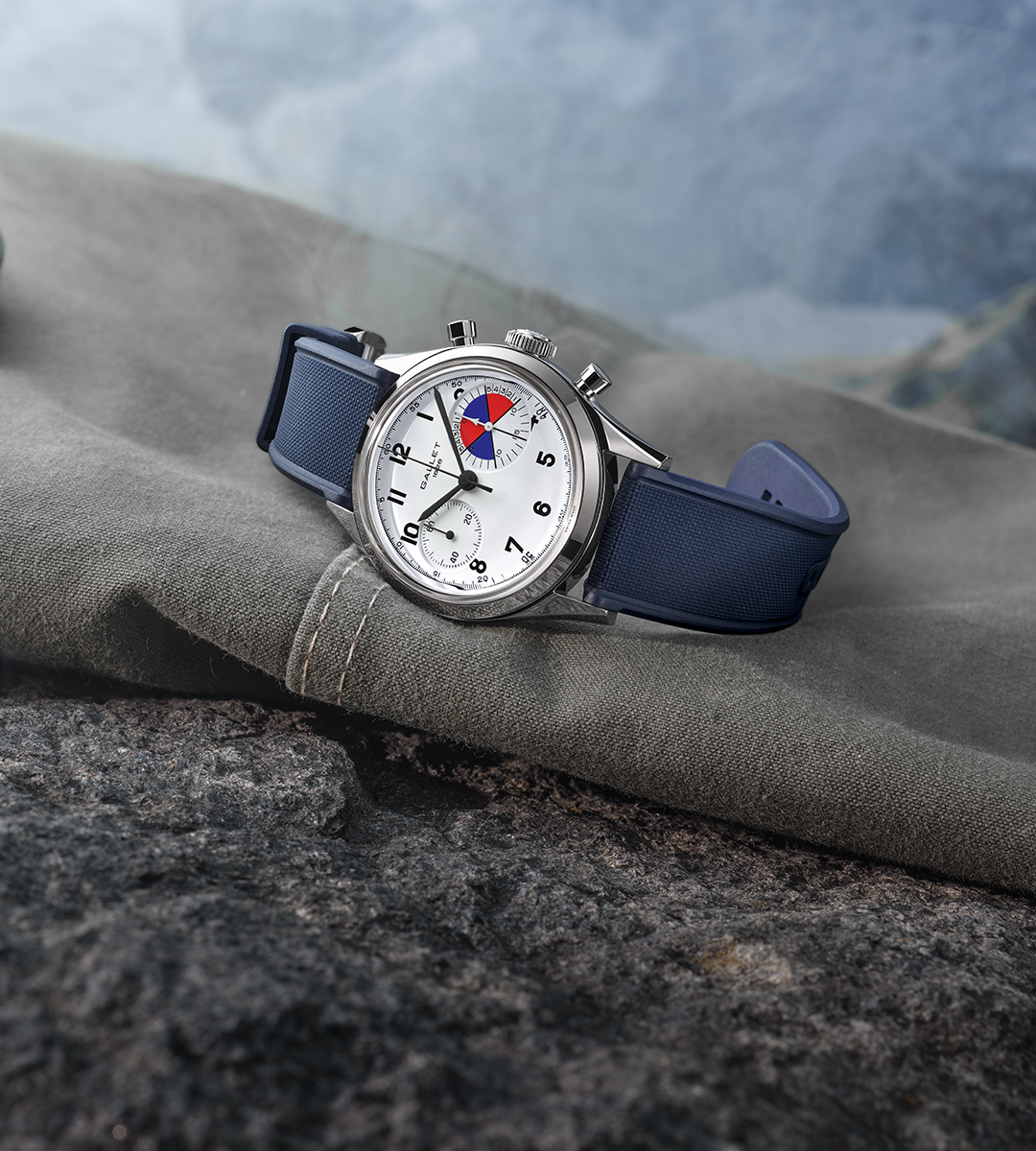 Gallet Tribute to Yachting Big Eye 38 mm, cadran blanc et bracelet caoutchouc bleu, posée sur une toile en montagne
