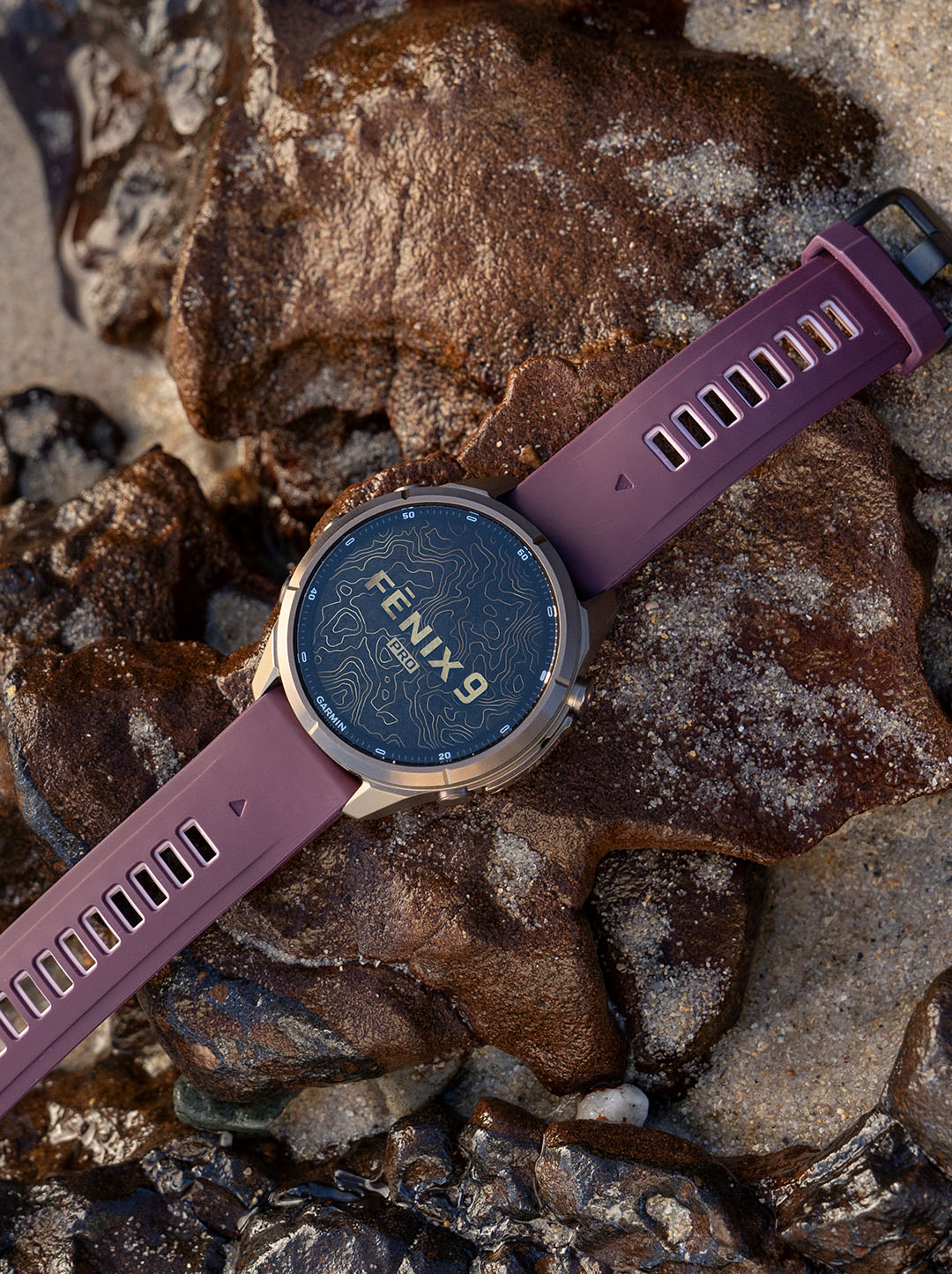 Montre Garmin Fenix 9 Pro posée sur la roche, cadran de présentation affiché