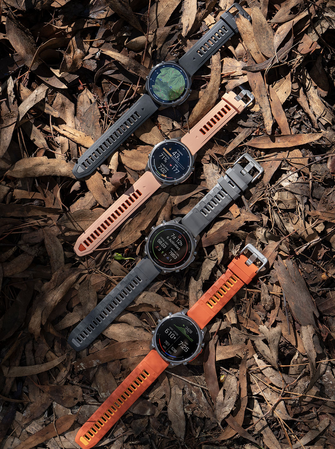Quatre montres Garmin Fenix 9 aux bracelets et écrans personnalisés, posées à plat