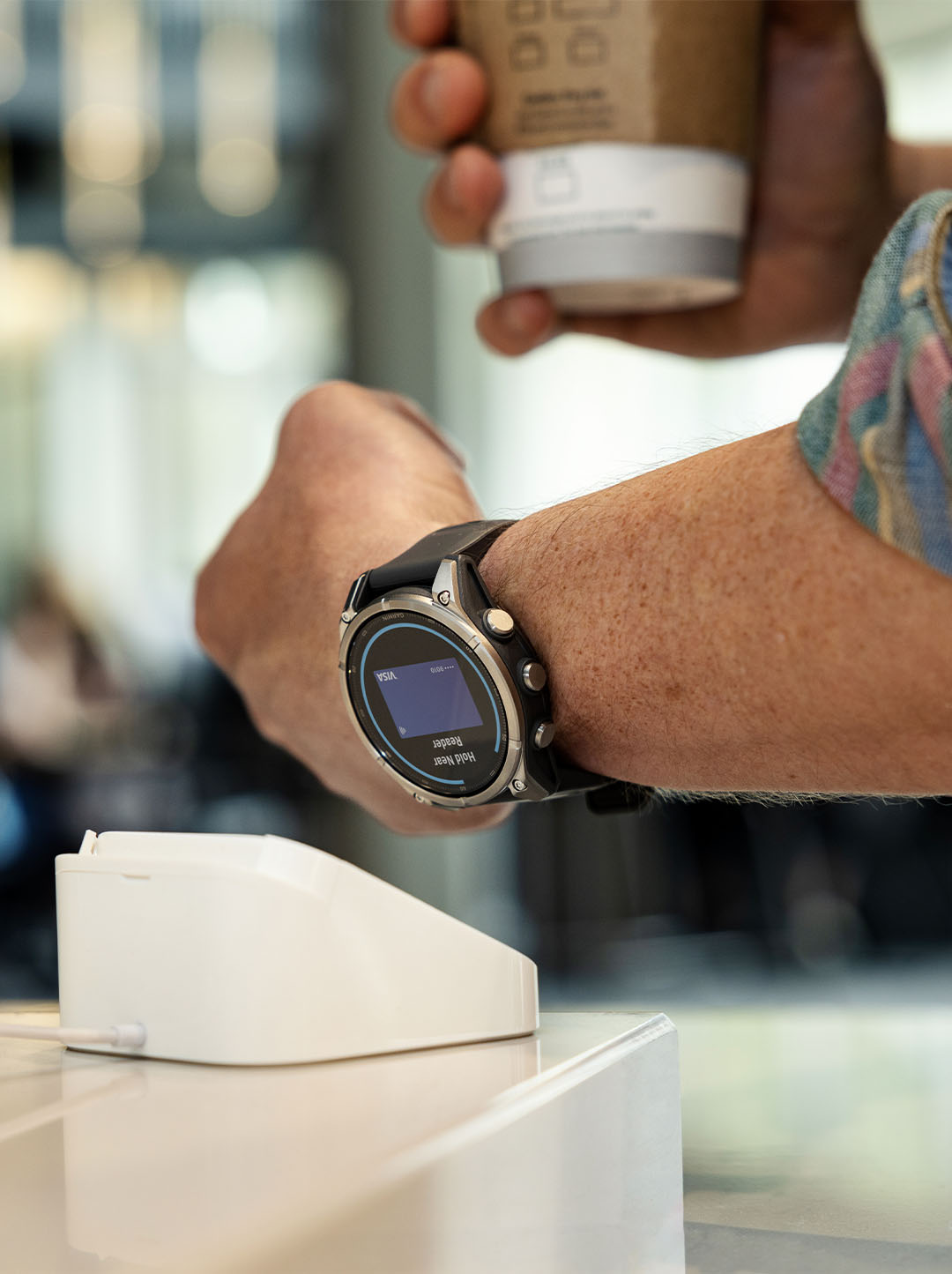 Paiement sans contact avec Garmin Pay, montre Garmin Fenix 9 approchée du terminal de paiement