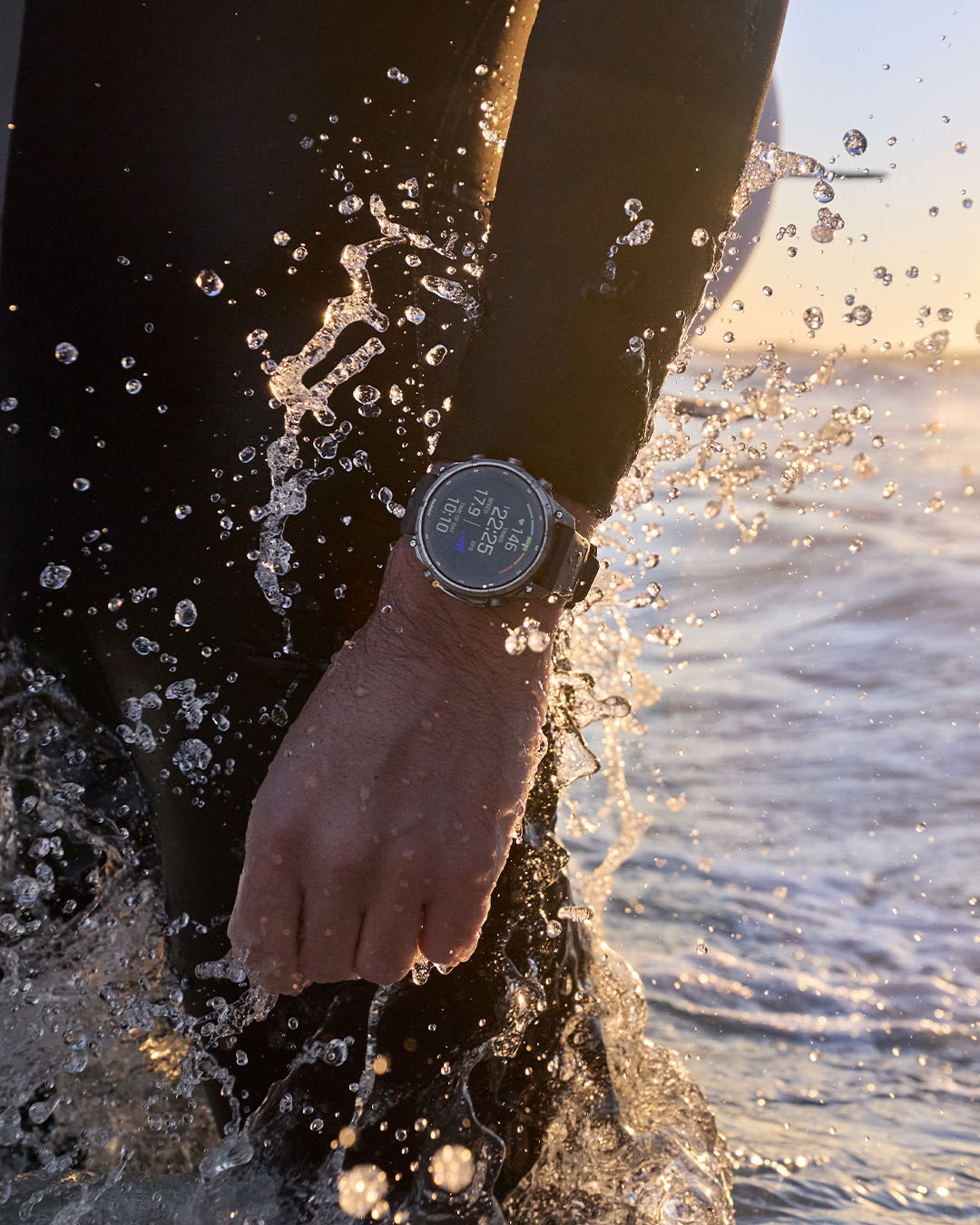 Montre Garmin Fenix 9 au poignet d'un surfeur sortant de l'eau, écran d'activité nautique affiché