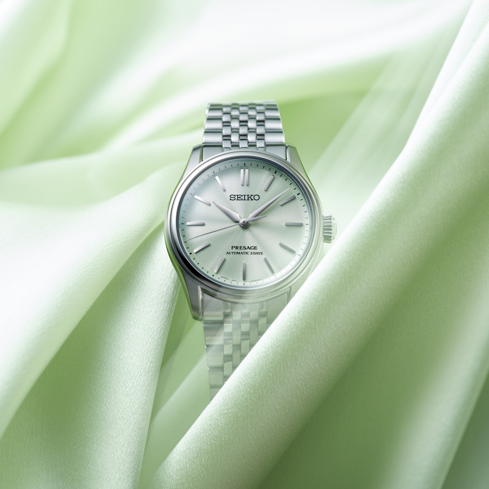 Montre Seiko Presage Classic Series HCC002J1 automatique 38 mm, cadran vert wakatake, bracelet acier, posée sur un bureau en noyer sous une lampe