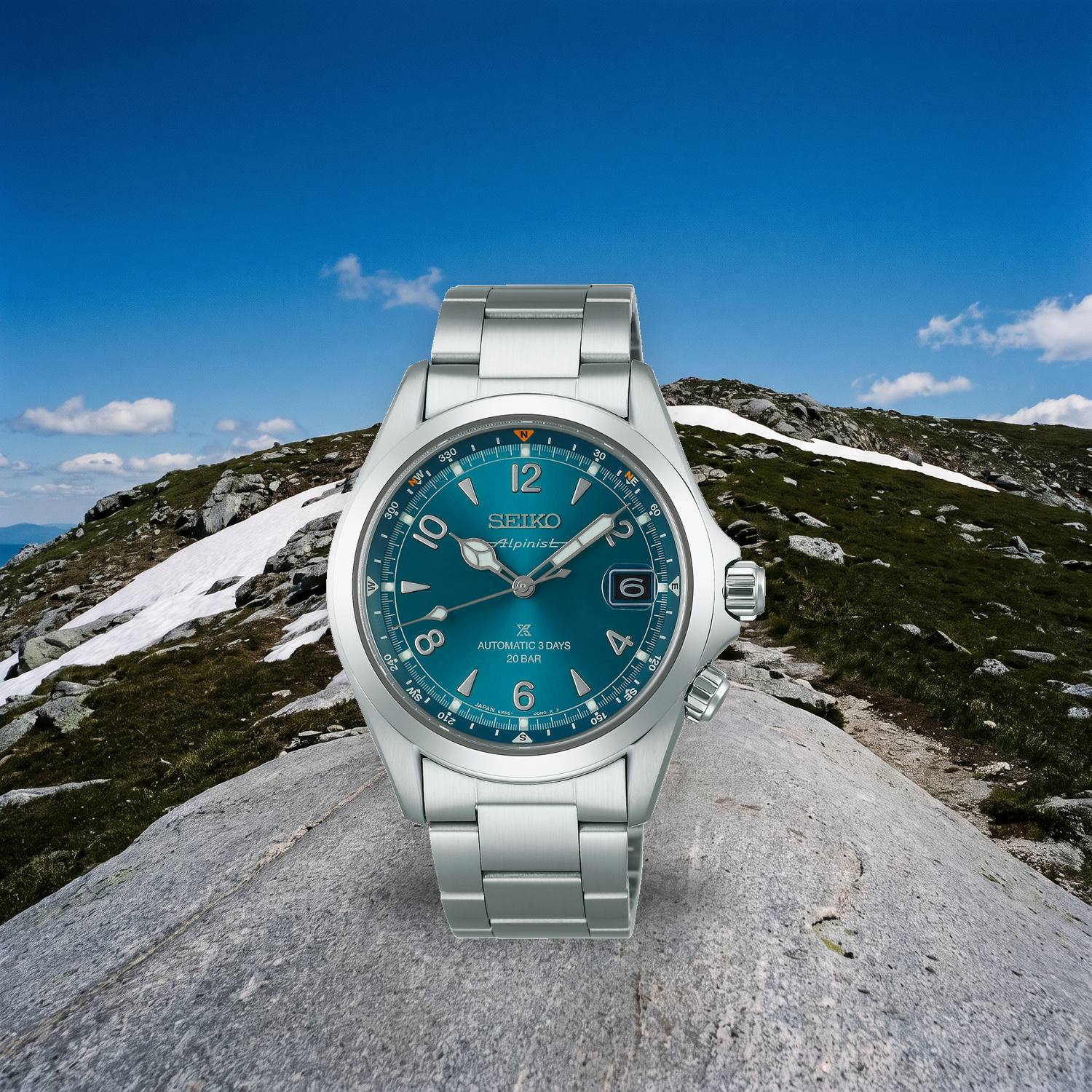 Montre Seiko Prospex Alpinist SPB503J1 automatique 39,5 mm, cadran bleu, bague boussole interne, bracelet acier, posée sur une pierre plate en crête alpine