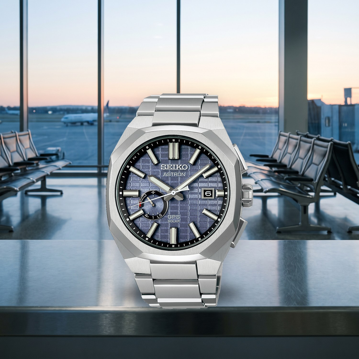Montre Seiko Astron GPS Solaire SSJ013J1 titane 41,2 mm, cadran bleu, bracelet titane, posée dans une porte d'embarquement à l'aube